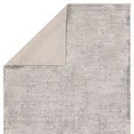 Rug corner folded to show plain beige underside contrasting with floral pattern
