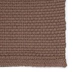 Extreme close-up focusing on the chunky weave pattern and looped fibers of the rug's surface.