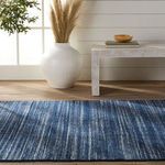 Danan rug displayed in bright room with pampas grass vase and textured cream bench on wood floor