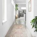 Skye Gold Blush rug shown as a long runner in a bright hallway with polished concrete floor and light walls