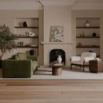 Wide living room scene with olive Davie Sofa, coffee table, rug, and neutral-toned armchairs.