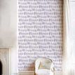 Wallpaper applied in a bright room with white chair, curtain, and hardwood floor, highlighting scale and room styling