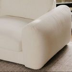 Close-up of Berga sectional arm resting on a textured area rug near window
