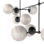 Close-up of several marbled glass spheres with visible handblown texture and black metal socket fittings