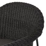 Close-up of curved rolled arm detailing in woven wicker with metal frame support