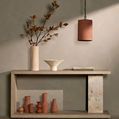 Enver rug’s pattern visible beneath a minimalist console table with vases and a hanging terracotta light fixture
