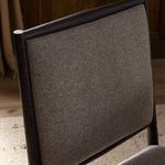 Backrest close-up in a room setting with wooden panel walls and stone flooring