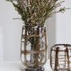 Close-up side angle showing two vases of different sizes with plaid swirl pattern, one filled with stems