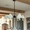 Ingela chandelier hanging in kitchen with exposed wooden beams and stainless steel appliances