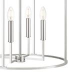 Close-up of three chrome candle-style bulb holders with clear bulbs and round metal base ring