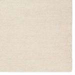 Rug edge showing finely finished border and uniform beige braided texture