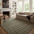 Bradley Sage rug in living room setting with sofa, leather chair, and fireplace