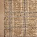 Detailed shot of Judy Natural / Stone Rug edge showing plaid pattern and artisanal weave on wood floor