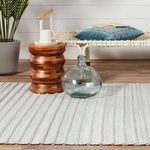 Edge detail of Torre rug with soft light gray and cream woven yarns and fringe