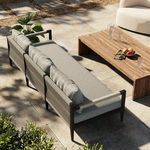 Outdoor scene with Sherwood sofa on patio next to wooden coffee table and greenery