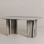 Three-quarter view of Celia Oval Dining Table showing tabletop thickness and pillar leg positioning in neutral setting