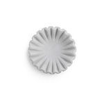 Small white marble bowl with soft ruffled edges and smooth finish, viewed from above