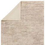 Top corner of the rug folded to reveal the cream woven backing contrasting with the abstract pile surface