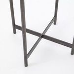 Close-up of crossed aluminum leg support showing hammered texture and welding details