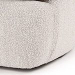Close-up of textured light fog bouclé fabric on chair base corner