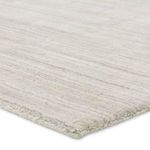 Close-up of rug edge showing soft woven texture and light gray tones