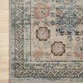 Zoomed detail of corner of Jocelyn Sky rug on wooden floor showing worn vintage pattern and colors