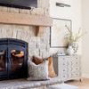 Decorative living room fireplace area featuring Kaz pillow paired with tan velvet pillow