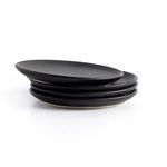 Stack of matte black ceramic salad plates with one plate slightly offset showing thickness
