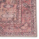 Close-up of rug corner showing detailed woven edges and intricate faded pink and purple pattern