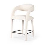 Three-quarter angle view showing the open curved back design and black metal footrest of the stool.