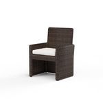 Three-quarter angled view showing chair depth and armrest height in Cognac resin wicker