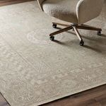 Close-up of the rug under a rolling office chair highlighting soft texture and muted design