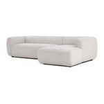 Angled right side view of sectional showing low profile and large rounded cushions in beige fabric