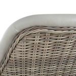 Tight view of upper wicker weave pattern under curved, padded vinyl sofa rim