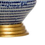 Close-up of antique gold leaf round base with textured blue and white porcelain above