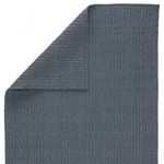 Area rug corner folded to reveal braided texture on both sides