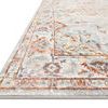 Close-up angled view showing rug's low pile texture and edge detail in grey and rust colors
