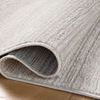 Corner of the rug curled up revealing its backing and edge binding
