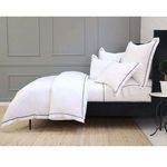 Side angle showing duvet set on black twin bed frame against gray paneled wall, pillows upright