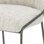 Close-up on seat edge showing fabric texture meeting brushed slate metal frame