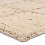 Close-up angled view showing thick wool pile and looped texture of the Kizza rug edge