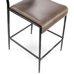 Close-up of seat cushion with leather surface and metal frame beneath