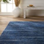 Rug corner beneath console table highlighting woven texture and speckled navy cream fibers