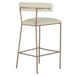 Three-quarter rear angle highlighting brass-finished legs and seamless white faux leather upholstery