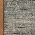 Corner of rug on wood floor highlighting texture and color variations in lagoon and sage