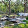 Outdoor seating area featuring Havana Swivel Club Rocker surrounded by greenery and stone water feature