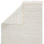 Top view showing corner folded over to reveal reverse side of light gray and cream Torre rug