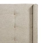 Top corner close-up of tufted headboard showing stitching and fabric texture