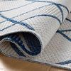 Rolled corner close-up of Easton Ivory Denim Rug highlighting weave structure and pliability in ivory and denim blue