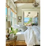 Cozy bed with Blake White/Ocean Duvet in a sunlit room overlooking ocean through open doors